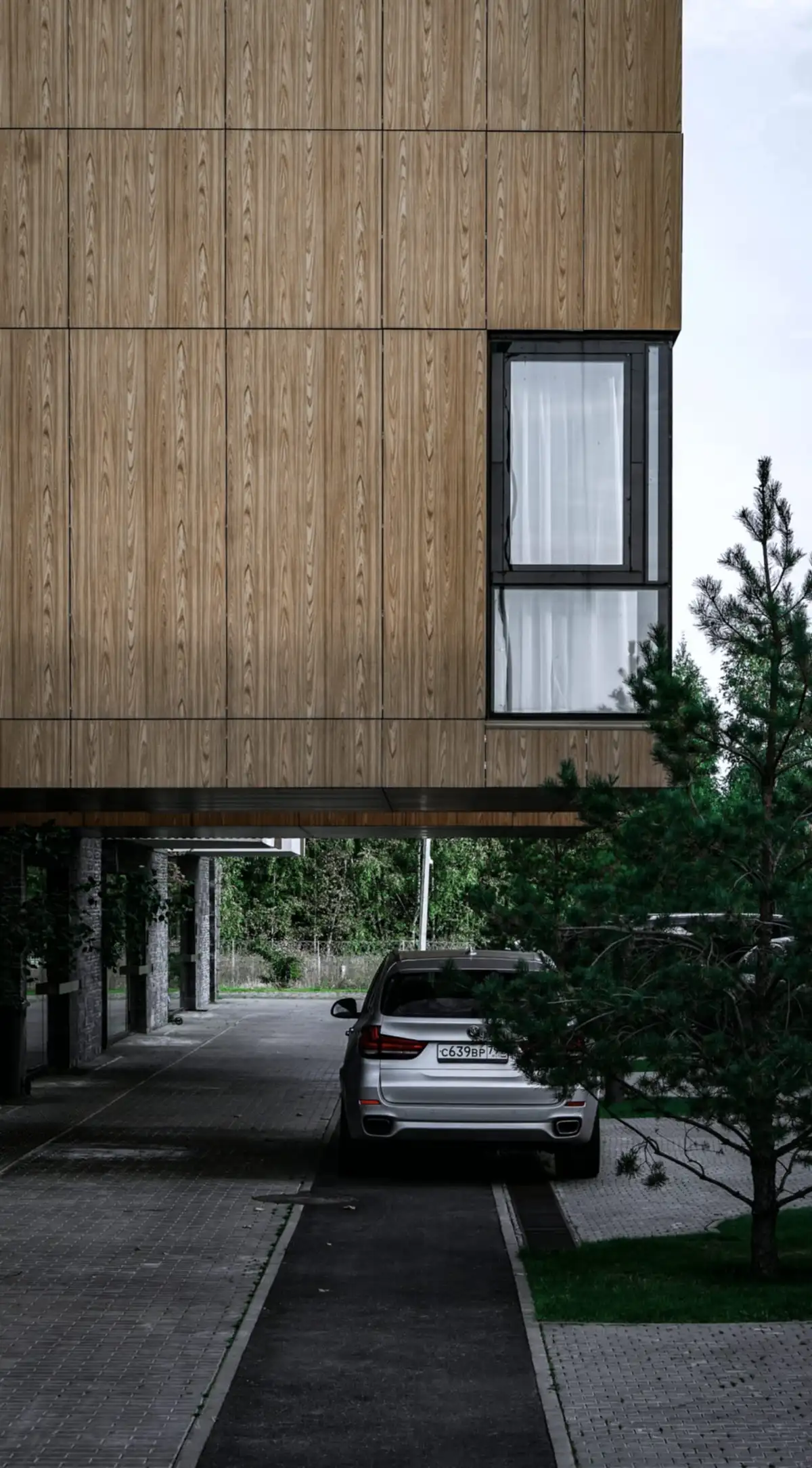 林の中に建つ、木の外壁の 2 階建ての住宅
